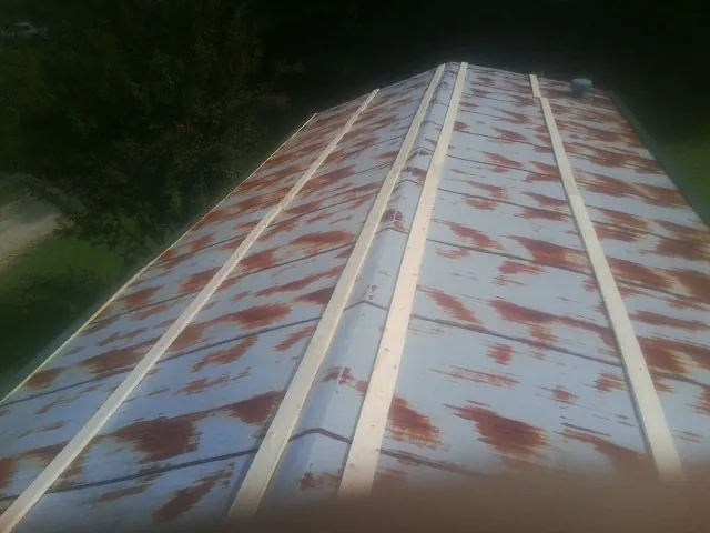 Rusted metal roof panels with new wood purlins before replacement — Storm Damage Roof Repair in San Andreas by Roofing Brothers