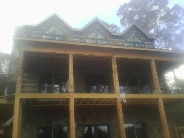 Dormers and porch framing on a large log home under construction — Roof Coating work by our crew in San Andreas