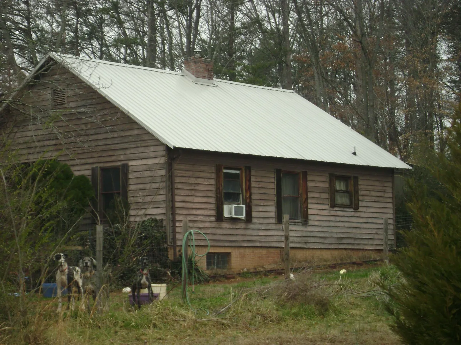 White metal roof on an old wood sided farmhouse, from a Metal Roof Installation job in San Andreas
